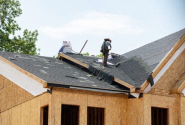 worker Installing asphalt roofing shingles